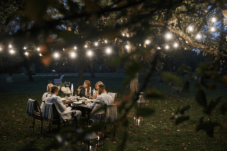 Tuinfeest lampjes tafel eten drinken vrienden